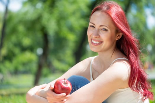 Portrait of a young attractive woman in the park. Smiling and happy