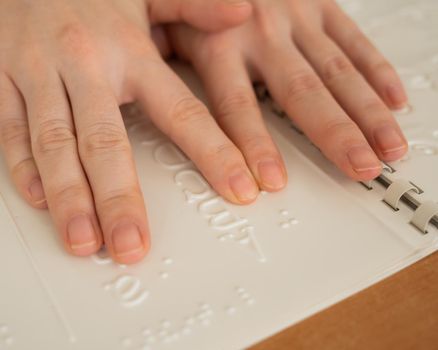 A woman learns the Braille alphabet using a decoder