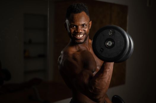 Attractive african american man smiling and doing exercise with dumbbells
