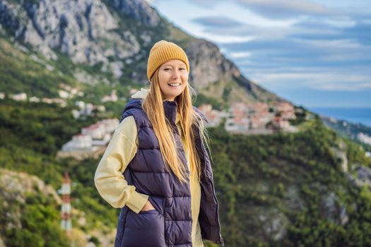 Woman in the mountains of Montenegro in warm clothes. Travel to Montenegro in spring, autumn, winter.