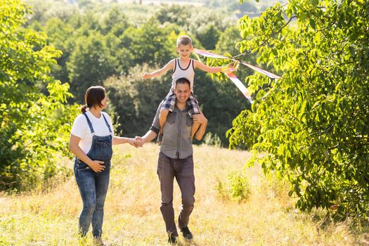 Young parents go with the son on the wheat field . The little son is happy when he is played.