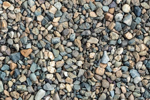 Colorful small pebbles. gravel texture on the background. Texture of little rocks. Small stones, little rocks, pebbles in many shades of grey, white, brown, yellow colour.