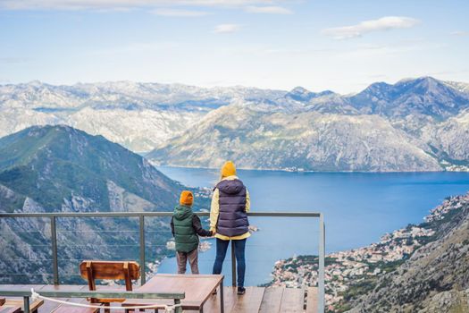 Mother and son travellers enjoys the view of Kotor. Montenegro. Bay of Kotor, Gulf of Kotor, Boka Kotorska and walled old city. Travel with kids to Montenegro concept. Fortifications of Kotor is on UNESCO World Heritage List since 1979.