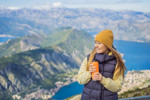 Woman tourist enjoys the view of Kotor. Montenegro. Bay of Kotor, Gulf of Kotor, Boka Kotorska and walled old city. Travel to Montenegro conceptFortifications of Kotor is on UNESCO World Heritage List since 1979.