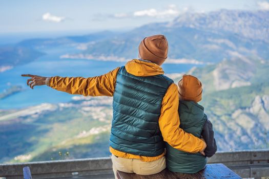 Dad and son travellers enjoys the view of Kotor. Montenegro. Bay of Kotor, Gulf of Kotor, Boka Kotorska and walled old city. Travel with kids to Montenegro concept. Fortifications of Kotor is on UNESCO World Heritage List since 1979.