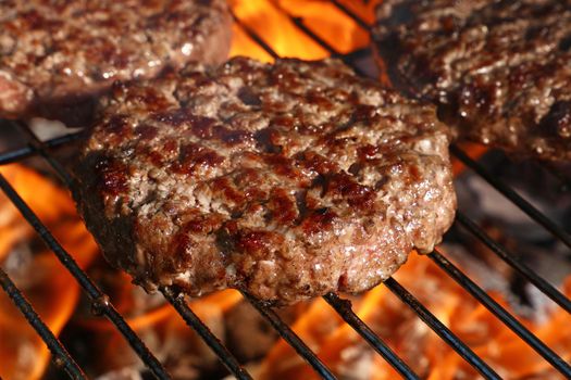 Close up beef or pork meat barbecue burgers for hamburger prepared grilled on bbq fire flame grill, high angle view