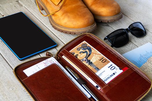 Tracking boot , tickets holder, map and sunglasses on the wooden background