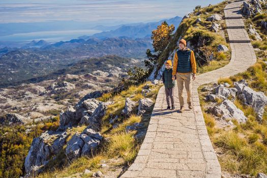 Dad and son travellers in mountain landscape at national park Lovcen, Montenegro. Travel to Montenegro with children concept.