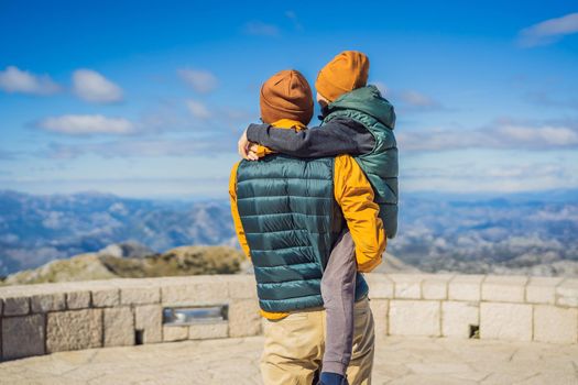 Dad and son travellers in mountain landscape at national park Lovcen, Montenegro. Travel to Montenegro with children concept.