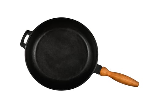 Close up one empty black cast iron frying pan with wooden handle isolated on white background, elevated top view, directly above