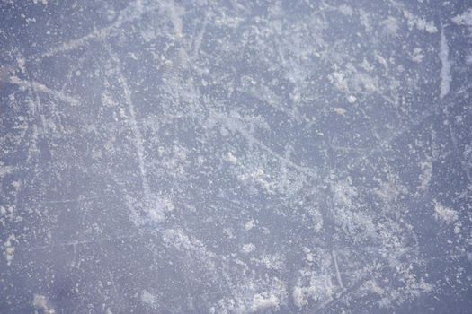 The texture of the ice skating rink, skated, closeup. Open ice rink winter background.