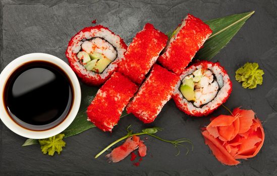 Close up set of six Boston or California sushi rolls served on black slate board, elevated top view, directly above