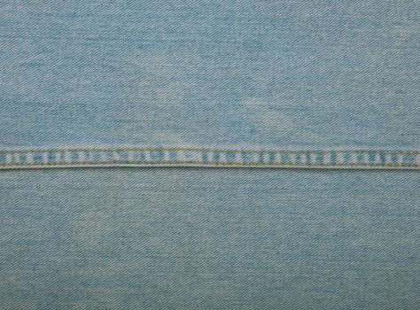 Light blue washed cotton jeans denim texture background with stitching seam edge line, close up