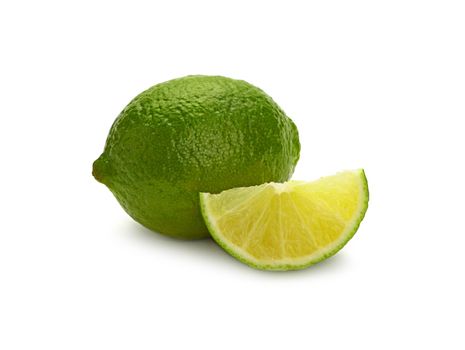 Close up one whole fresh green lime fruit and cut slice wedge, isolated on white background, low angle side view