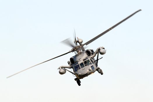 A low angle isolated shot of a military hawk maneuvring on a white background