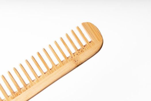 bamboo wood comb diagonally on white background with soft lighting