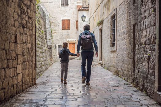 Dad and son travelers enjoying Colorful street in Old town of Kotor on a sunny day, Montenegro. Travel to Montenegro concept.