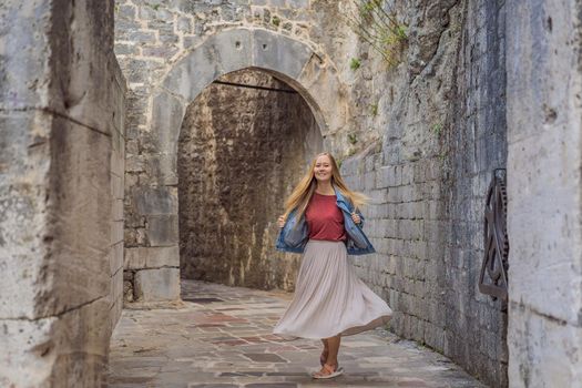 Woman tourist enjoying Colorful street in Old town of Kotor on a sunny day, Montenegro. Travel to Montenegro concept.