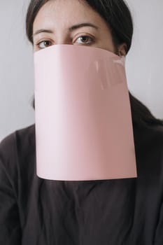 Beautiful asian woman applying paper sheet mask on her face white background