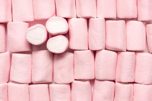 pink and white mini marshmallows occupying the entire image lying in horizontal rows except for three that are placed vertically on the left