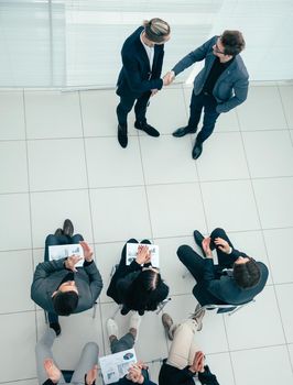 top view. business partners shaking hands before the presentation.