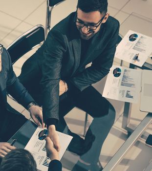 close up. financial partner shake hands over an office Desk. business concept.