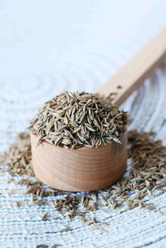 cumin seeds on spoon on table .