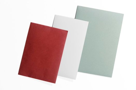 Green, burgundy and gray envelopes on a white surface