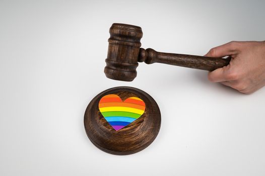 The judge hits a heart with a rainbow flag with a gavel