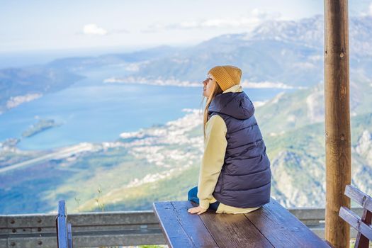 Woman tourist enjoys the view of Kotor. Montenegro. Bay of Kotor, Gulf of Kotor, Boka Kotorska and walled old city. Travel to Montenegro conceptFortifications of Kotor is on UNESCO World Heritage List since 1979.