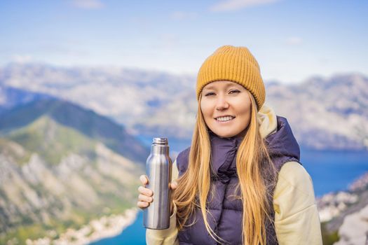 Woman tourist enjoys the view of Kotor. Montenegro. Bay of Kotor, Gulf of Kotor, Boka Kotorska and walled old city. Travel to Montenegro conceptFortifications of Kotor is on UNESCO World Heritage List since 1979.