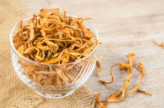 The Dried cordyceps militaris mushroom flower on wooden background.