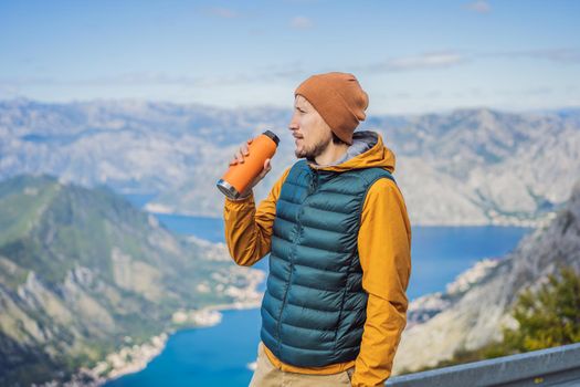 Man tourist enjoys the view of Kotor. Montenegro. Bay of Kotor, Gulf of Kotor, Boka Kotorska and walled old city. Travel to Montenegro concept. Fortifications of Kotor is on UNESCO World Heritage List since 1979.