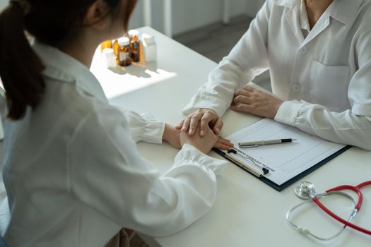 Asian female doctor in white medical uniform consult female patient in private hospital. woman therapist speak talk with woman client on consultation in clinic.