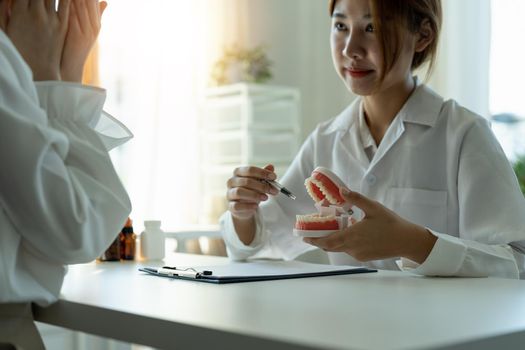 dentist and patient discussion about planned teeth treatment in dental clinic office - dentist consultation concept.