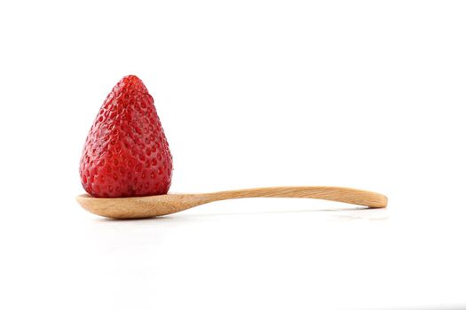 One fresh strawberry placed on a wooden spoon.