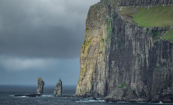 Dark cloudy sky with Risin og Kellingin sculpted rocks in faroe islands