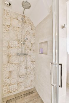 Bathroom in gray tones with a glass shower cabin in a modern house