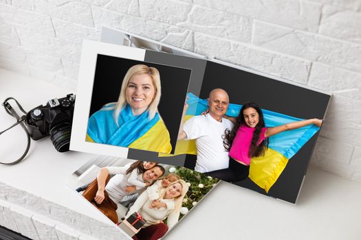 Family photos archive saved in brightly designed photo book; bright summer memories placed in the photobook. family with flag of ukraine.