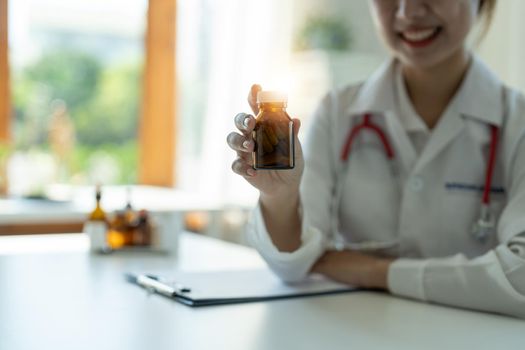 Female doctor hand holding pack of different tablet blisters at workplace closeup. Panacea, life save service, prescribe medicament, concept.