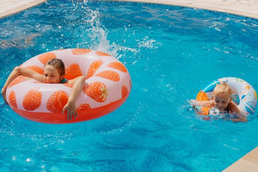 Happy child having fun on summer vacation. Kid playing with rubber duck and ball in the sea. Healthy lifestyle concept. Happy child playing in swimming pool. Summer vacations concept