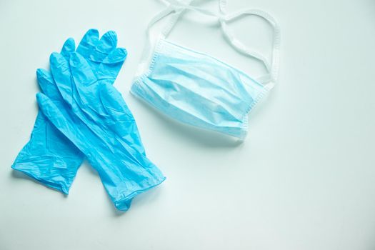 blue surgical gloves and face mask on white background