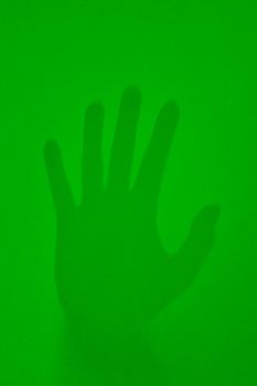 On a green background is the imprint of a man's hand