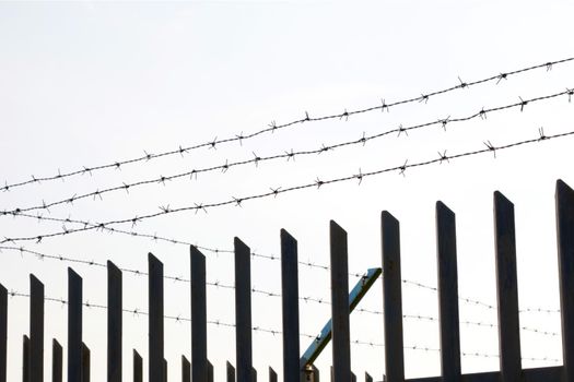 Barbed wire on the iron fence. Closure of borders. Passage is prohibited