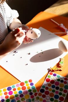 hand paints an Easter egg with a yellow brush close-up. The concept of the holiday and Easter decor. High quality photo