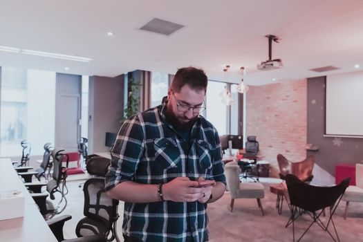 Office manager work in coworking space using smartphone analyzing online market trends, focused man worker reading financial news or browsing the internet on phone. Technology concept. High-quality photo