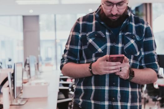 Office manager work in coworking space using smartphone analyzing online market trends, focused man worker reading financial news or browsing the internet on phone. Technology concept. High-quality photo