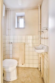 The interior of a spacious bathroom in a cozy apartment with a sink and toilet