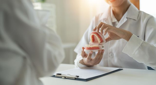 dentist and patient discussion about planned teeth treatment in dental clinic office - dentist consultation concept.