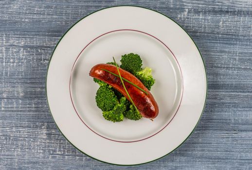 Sausage and broccoli on a plate -Top view